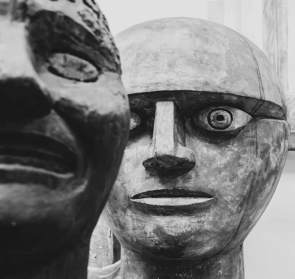 A carved mask-like human face in black and white