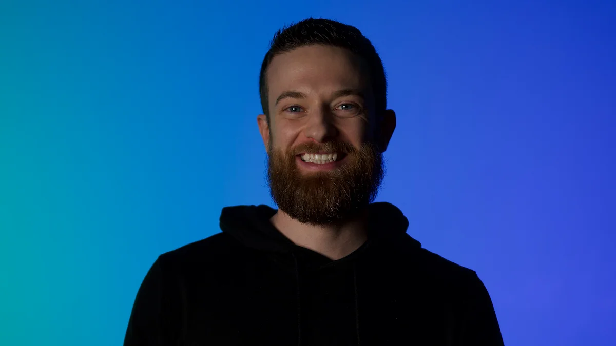 Keith Gilmore smiling in front of a blue background